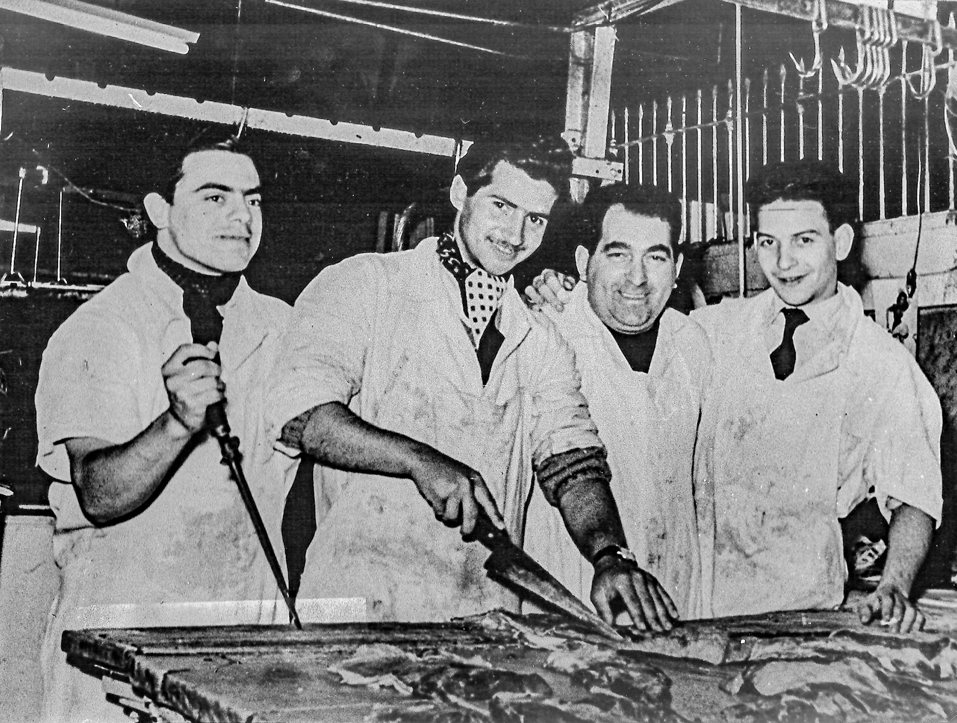 1955 cuatro hombres cortando carne